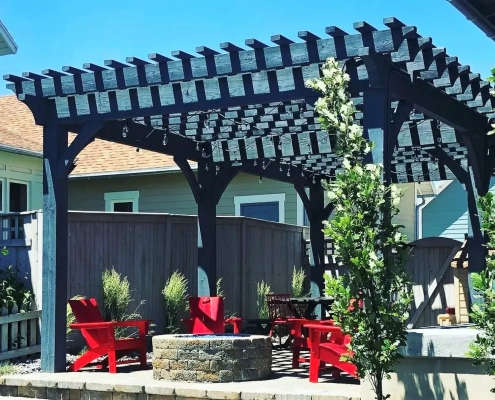 A wood pergola kit constructed over a fire pit