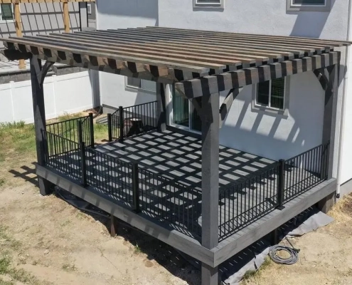 A backyard with a wood pergola over a deck